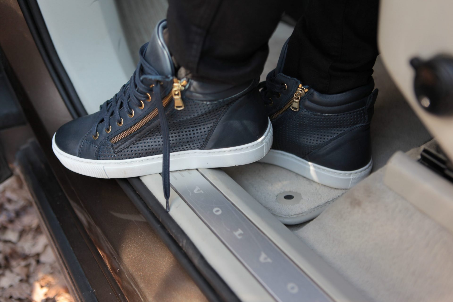 Sneakersy damskie na progu auta