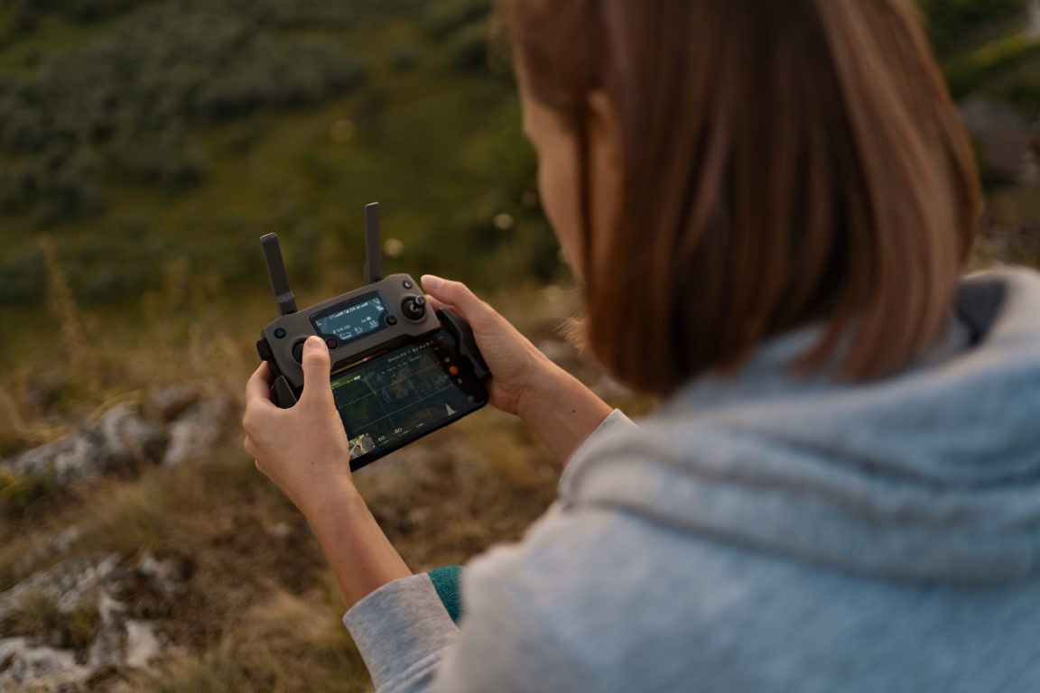 Woman in nature piloting a drone